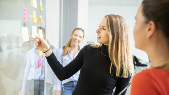 Women explains other women something on whiteboard