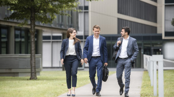 Three people walking outside the Campus